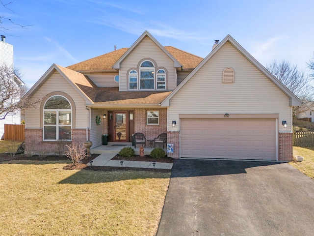 traditional-style home with a front yard, an attached garage, and brick siding