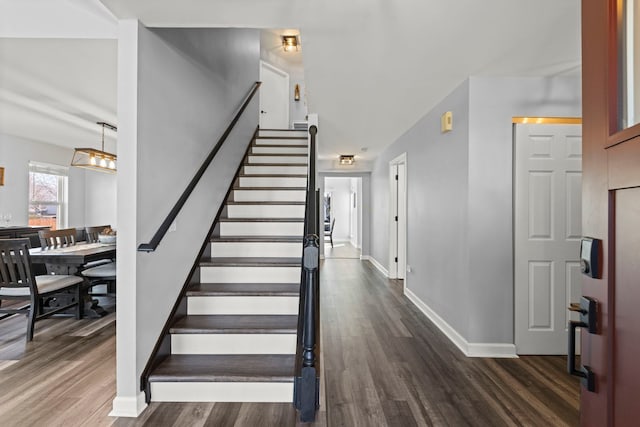 staircase featuring baseboards and wood finished floors