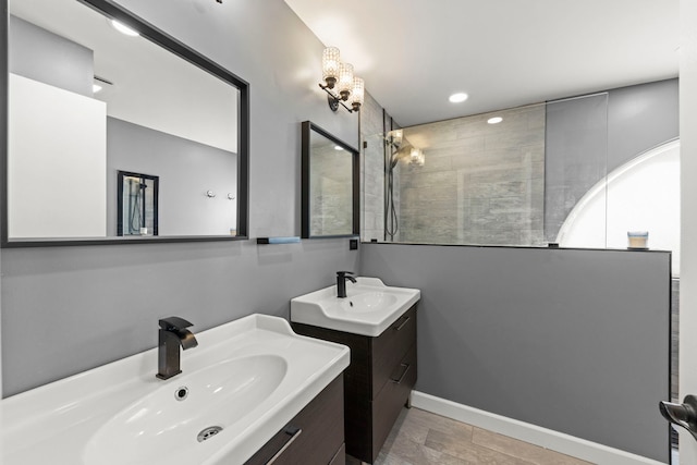 full bath with two vanities, a walk in shower, recessed lighting, and a sink