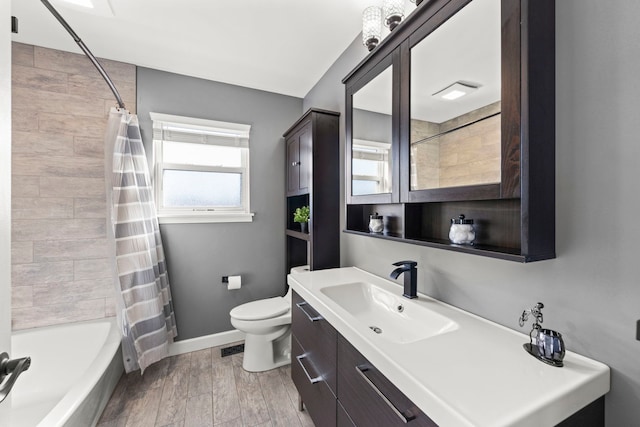 full bath with wood finish floors, baseboards, toilet, shower / tub combo with curtain, and vanity