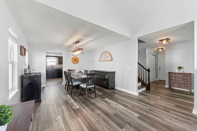 dining room with visible vents, stairs, baseboards, and wood finished floors