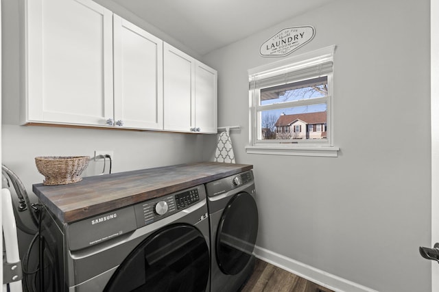 laundry room featuring dark wood-type flooring, cabinet space, independent washer and dryer, and baseboards