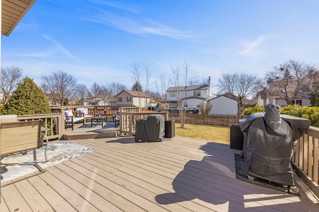 wooden deck with fence, a residential view, and grilling area