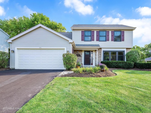 traditional home featuring a front lawn, brick siding, driveway, and an attached garage