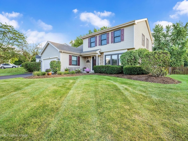 view of front facade with a front lawn, an attached garage, fence, and aphalt driveway