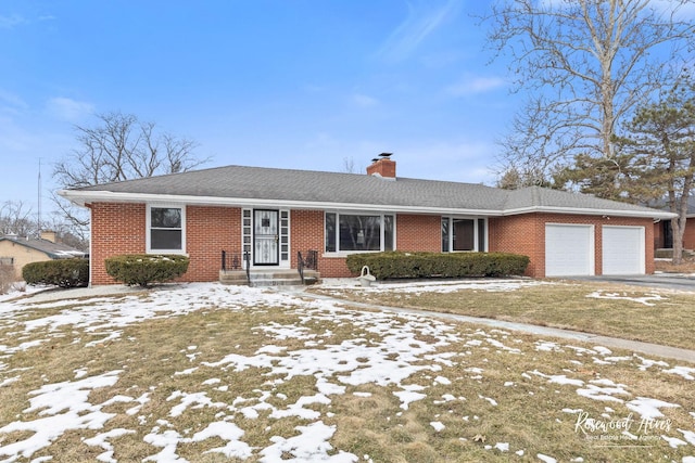 ranch-style home featuring a garage, driveway, brick siding, and a chimney