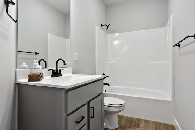 bathroom featuring toilet, shower / tub combination, wood finished floors, and vanity