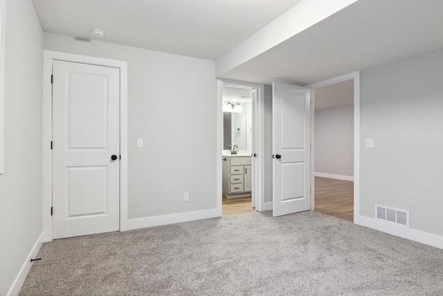unfurnished bedroom with carpet flooring, visible vents, and baseboards