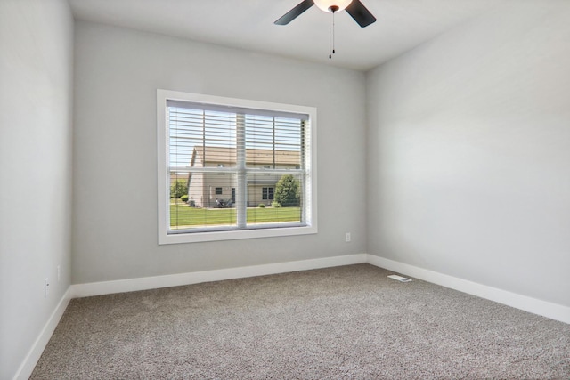 carpeted empty room with baseboards and a ceiling fan