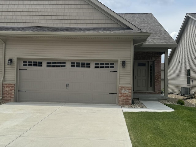 view of front facade with a garage, cooling unit, concrete driveway, and brick siding