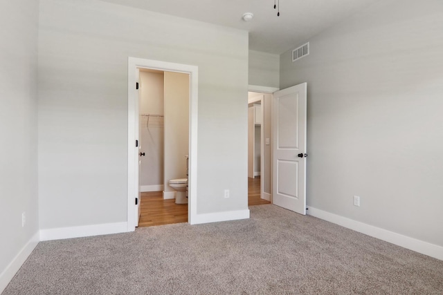 unfurnished bedroom featuring carpet floors, visible vents, and baseboards