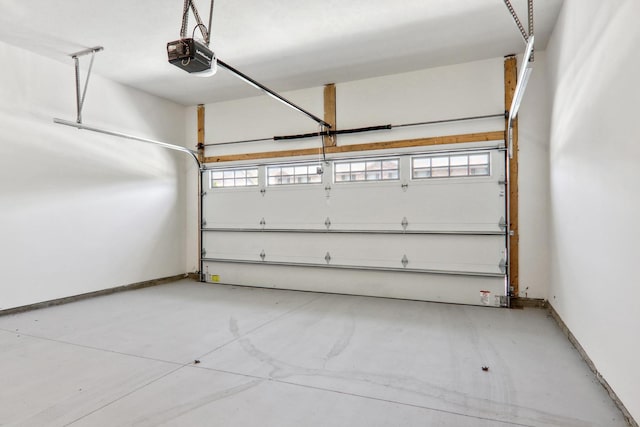 garage with a garage door opener and baseboards