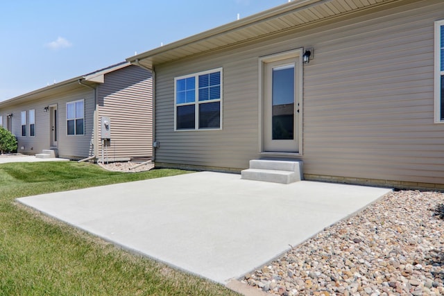 back of house featuring entry steps, a patio area, and a yard
