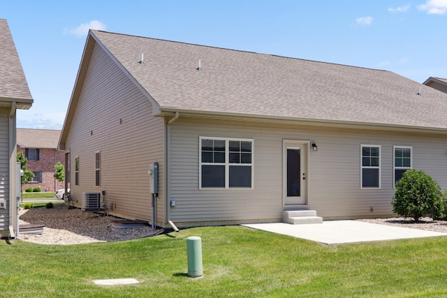back of house featuring entry steps, a yard, roof with shingles, and a patio