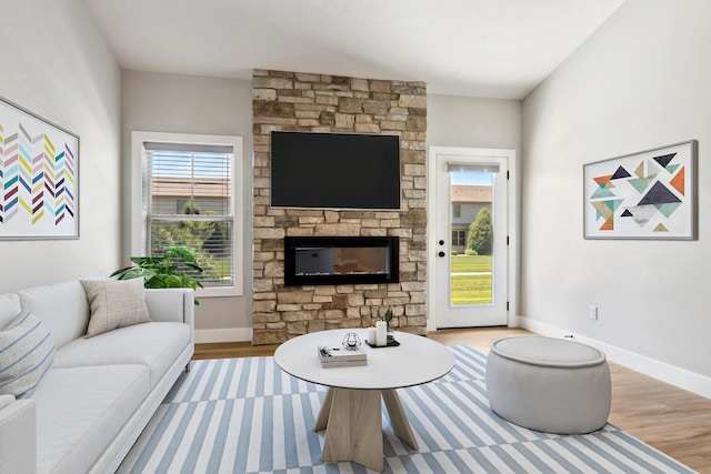 living area featuring light wood-style floors, a fireplace, and baseboards