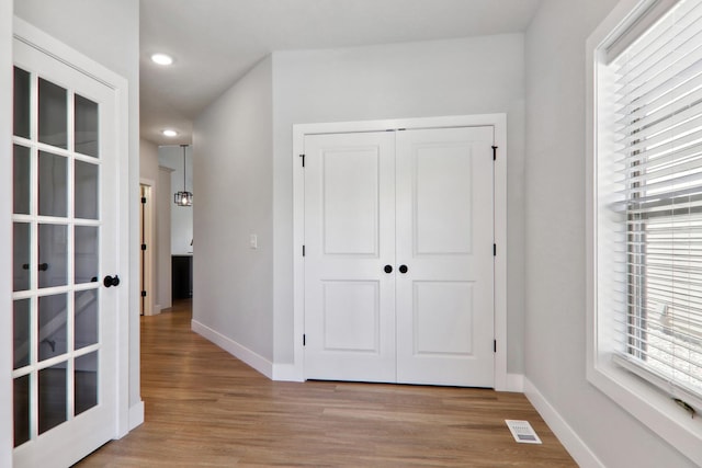 interior space featuring light wood-style flooring, visible vents, and baseboards