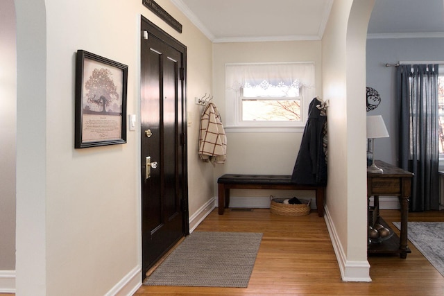 doorway to outside featuring light wood-style floors, baseboards, and ornamental molding