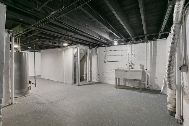 unfinished basement with gas water heater and a sink