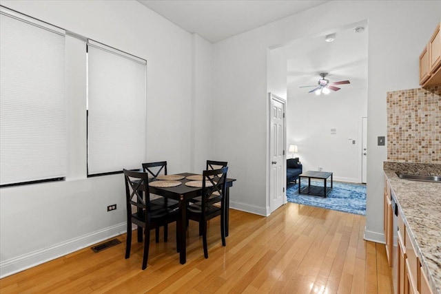 dining area featuring baseboards, light wood finished floors, visible vents, and a ceiling fan