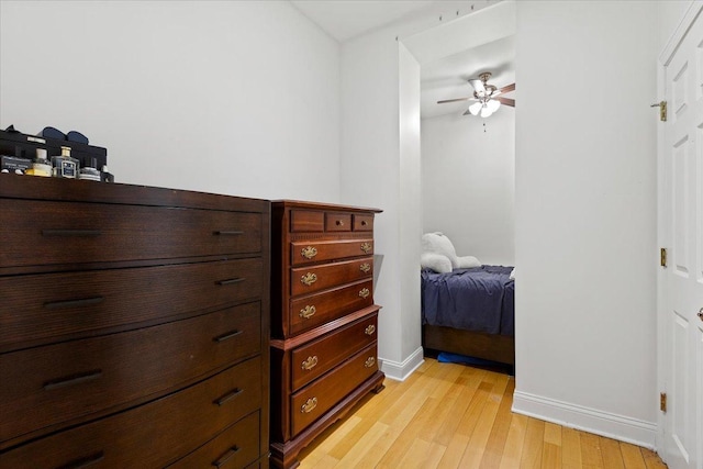 bedroom featuring light wood-style floors, baseboards, and a ceiling fan