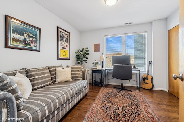 office with dark wood-style flooring, visible vents, and baseboards