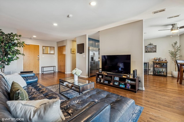 living area with baseboards, visible vents, wood finished floors, and recessed lighting