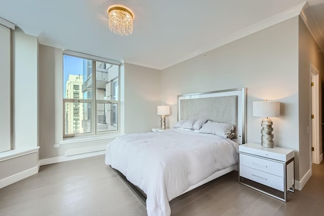 bedroom with a chandelier, ornamental molding, dark wood-style flooring, and baseboards