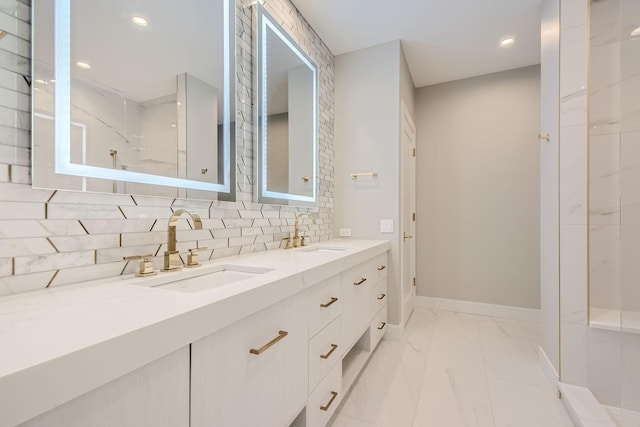 bathroom with marble finish floor, baseboards, decorative backsplash, and a sink