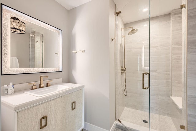 bathroom featuring a stall shower, vanity, and baseboards