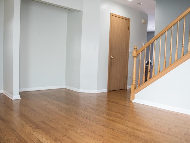 interior space with stairs, baseboards, and wood finished floors