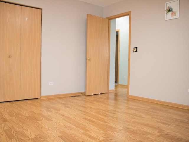 unfurnished bedroom featuring light wood-type flooring and baseboards