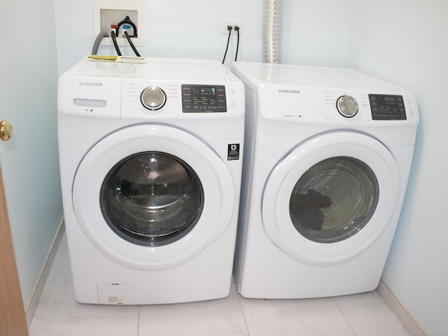 laundry room featuring marble finish floor, laundry area, independent washer and dryer, and baseboards