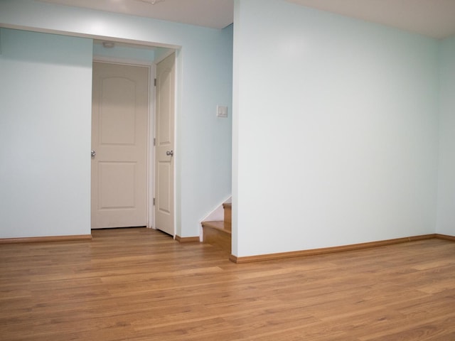 spare room featuring light wood-type flooring and baseboards