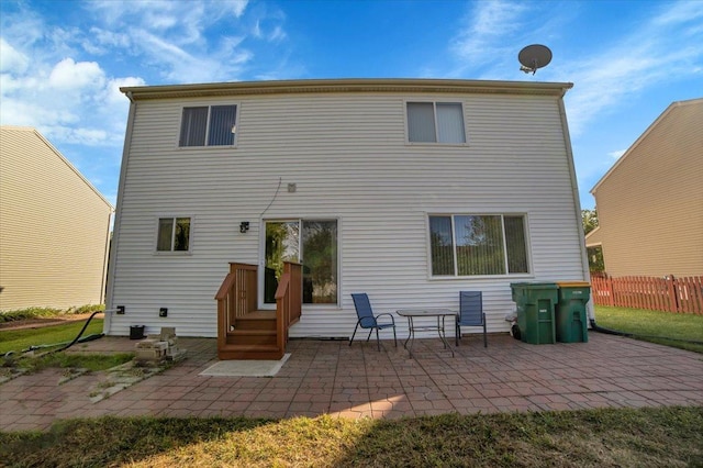 rear view of house with a patio and fence