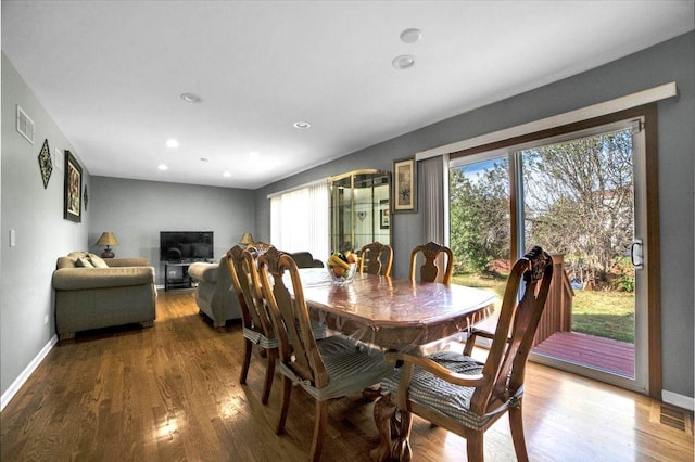 dining room with wood finished floors, visible vents, and baseboards