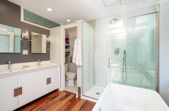 bathroom featuring a stall shower, a sink, and wood finished floors