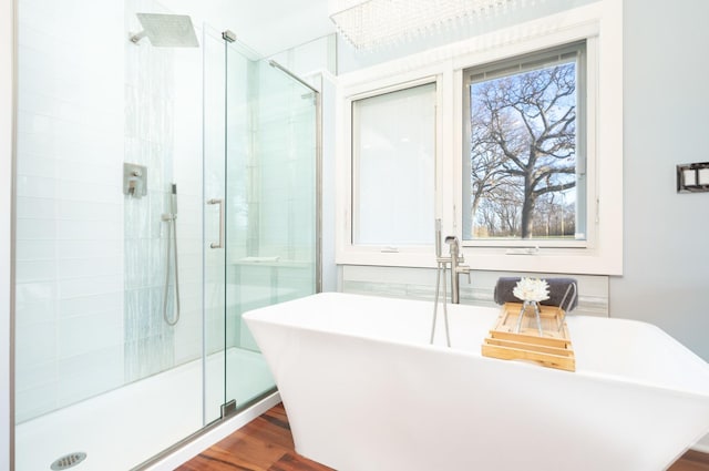 full bath featuring a freestanding bath, a stall shower, and wood finished floors