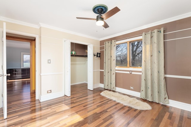 unfurnished bedroom with baseboards, a closet, ornamental molding, and wood finished floors