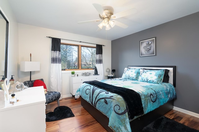 bedroom with ceiling fan, baseboards, and wood finished floors