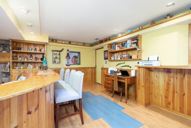 home office with recessed lighting, light wood-style flooring, wooden walls, and wainscoting