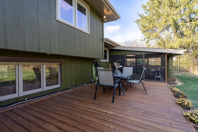 deck with outdoor dining space and a sunroom