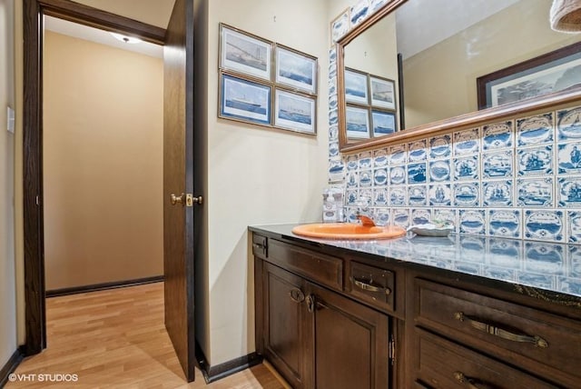 bathroom with baseboards, wood finished floors, and vanity