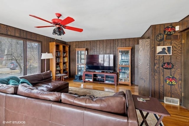 living room with a ceiling fan, visible vents, a wealth of natural light, and wood finished floors