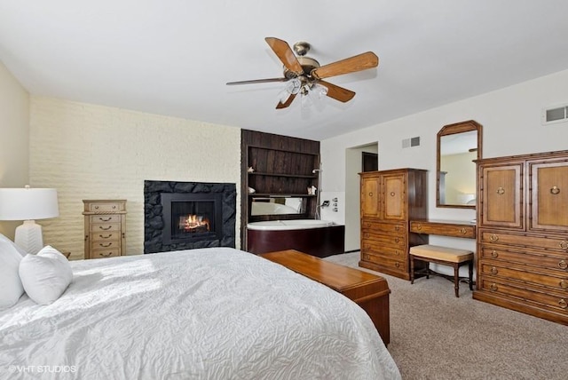 bedroom featuring carpet floors, visible vents, a lit fireplace, and a ceiling fan