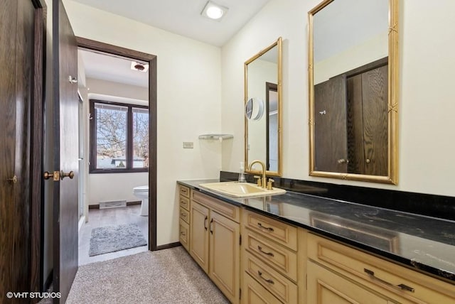 bathroom featuring visible vents, vanity, toilet, and baseboards