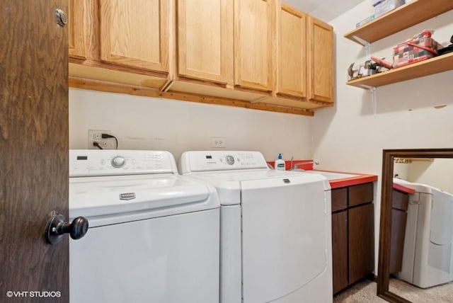 laundry area with cabinet space, a sink, and washer and clothes dryer