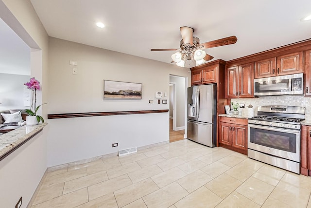 kitchen with stainless steel appliances, tasteful backsplash, visible vents, a ceiling fan, and baseboards