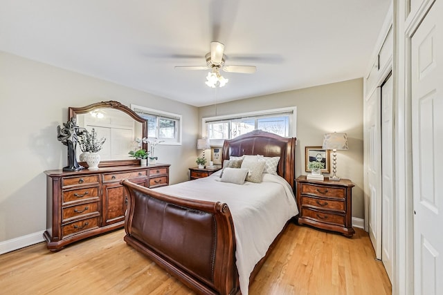 bedroom with light wood-style flooring, baseboards, and ceiling fan