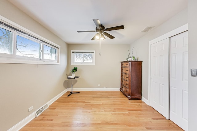 bedroom featuring a closet, light wood-type flooring, visible vents, and baseboards