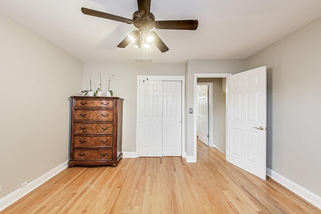 unfurnished bedroom with light wood finished floors, visible vents, baseboards, and a closet